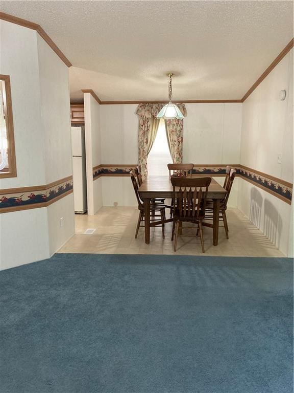 2000 E 19th St Unit 5, Lawrence, KS 66046 - dining space with crown molding, a textured ceiling, and light carpet