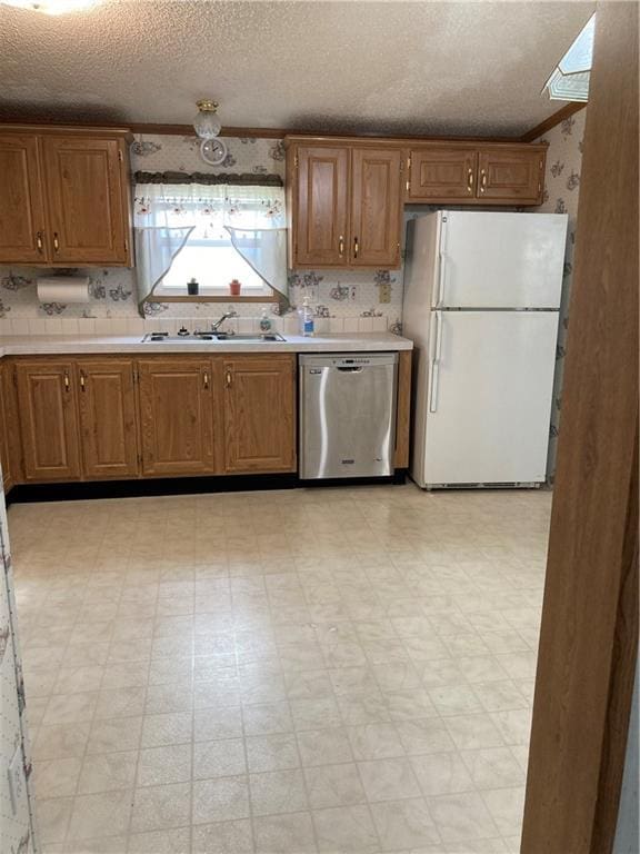 2000 E 19th St Unit 5, Lawrence, KS 66046 - kitchen with freestanding refrigerator, stainless steel dishwasher, light countertops, light flooring, and a textured ceiling