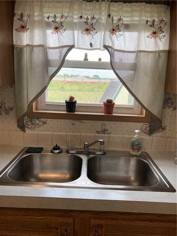 2000 E 19th St Unit 5, Lawrence, KS 66046 - detailed view of brown cabinets, decorative backsplash, and light countertops
