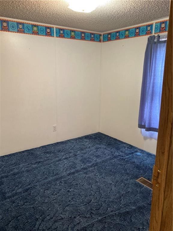2000 E 19th St Unit 5, Lawrence, KS 66046 - unfurnished room featuring carpet flooring and a textured ceiling