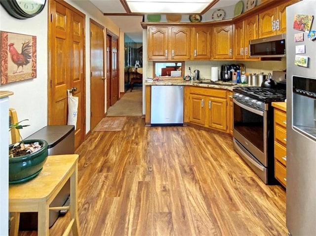 305 E Partridge Ave, Independence, MO 64055 - kitchen with appliances with stainless steel finishes, light wood-style floors, and brown cabinets
