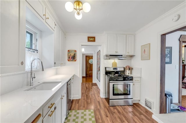 617 E 64th Ter, Kansas City, MO 64131 - kitchen featuring stainless steel appliances, under cabinet range hood, a sink, light wood-type flooring, and ornamental molding