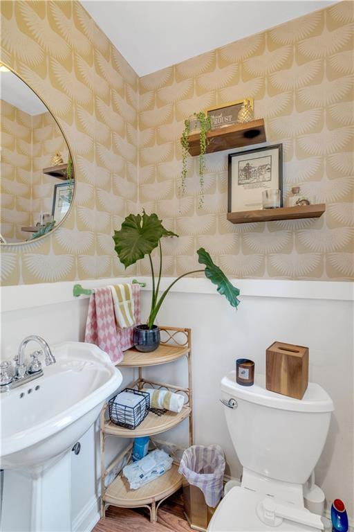 617 E 64th Ter, Kansas City, MO 64131 - half bath featuring toilet, wallpapered walls, and wood finished floors