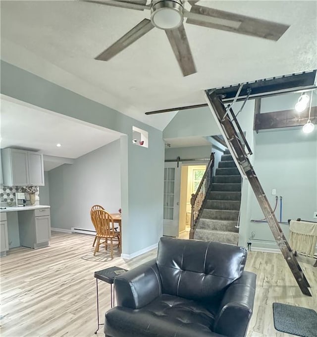 10057 Otter Rd, Clinton, MO 64735 - living area featuring a barn door, a ceiling fan, baseboards, light wood-type flooring, and stairs