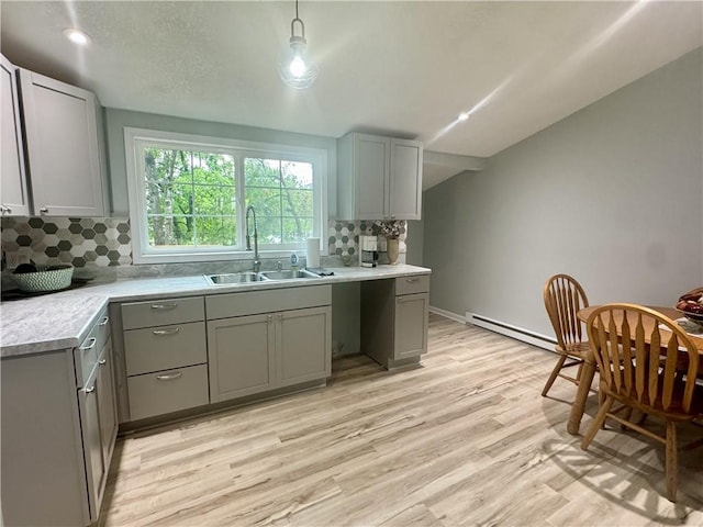 10057 Otter Rd, Clinton, MO 64735 - kitchen featuring a sink, gray cabinets, a baseboard radiator, tasteful backsplash, and light wood-type flooring