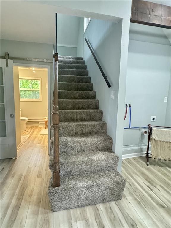 10057 Otter Rd, Clinton, MO 64735 - stairway with a barn door and wood finished floors