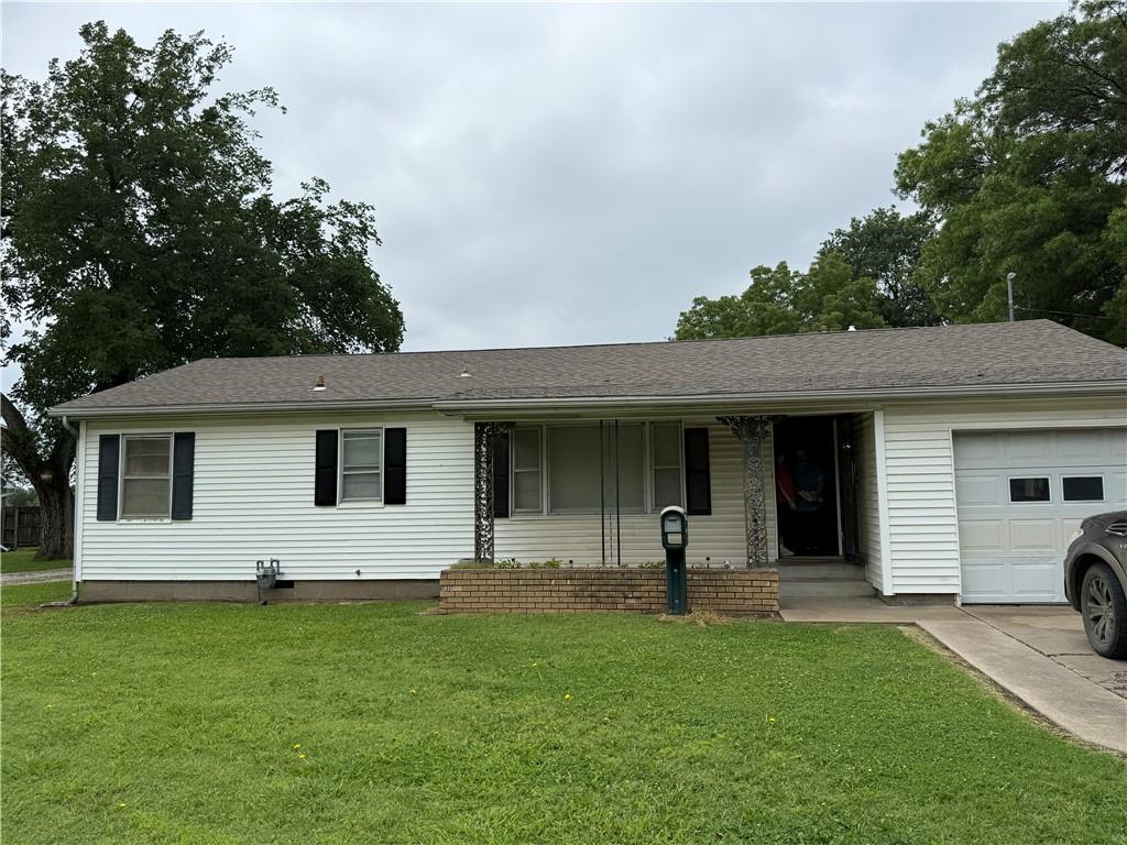 902 W 1st St, Coffeyville, KS 67337 - single story home featuring a garage, a front yard, and covered porch