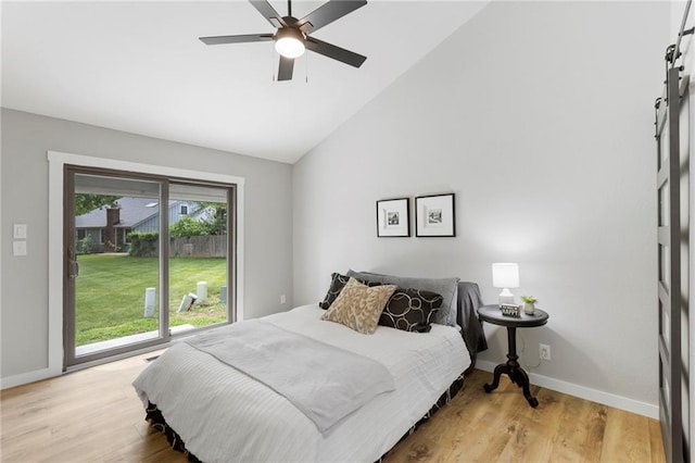 11917 W 66th St, Shawnee, KS 66216 - bedroom featuring a barn door, light wood-style floors, access to exterior, high vaulted ceiling, and ceiling fan