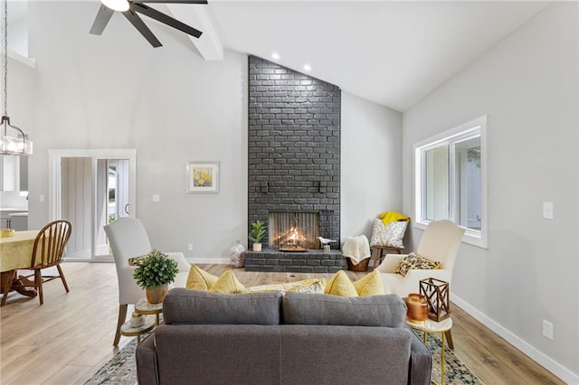 11917 W 66th St, Shawnee, KS 66216 - living area with high vaulted ceiling, beamed ceiling, light wood finished floors, a brick fireplace, and a ceiling fan