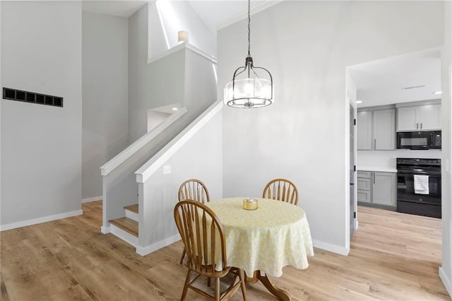 11917 W 66th St, Shawnee, KS 66216 - dining room featuring a chandelier, stairs, and light wood finished floors