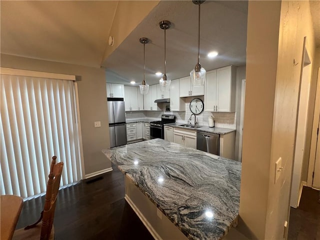 8237 N Chatham Ave, Kansas City, MO 64151 - kitchen featuring stainless steel appliances, a sink, white cabinets, tasteful backsplash, and under cabinet range hood
