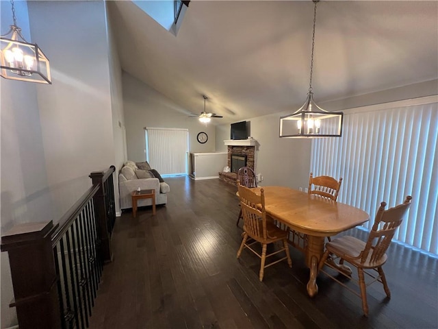 8237 N Chatham Ave, Kansas City, MO 64151 - dining space with a chandelier, dark wood finished floors, a fireplace with raised hearth, ceiling fan, and high vaulted ceiling