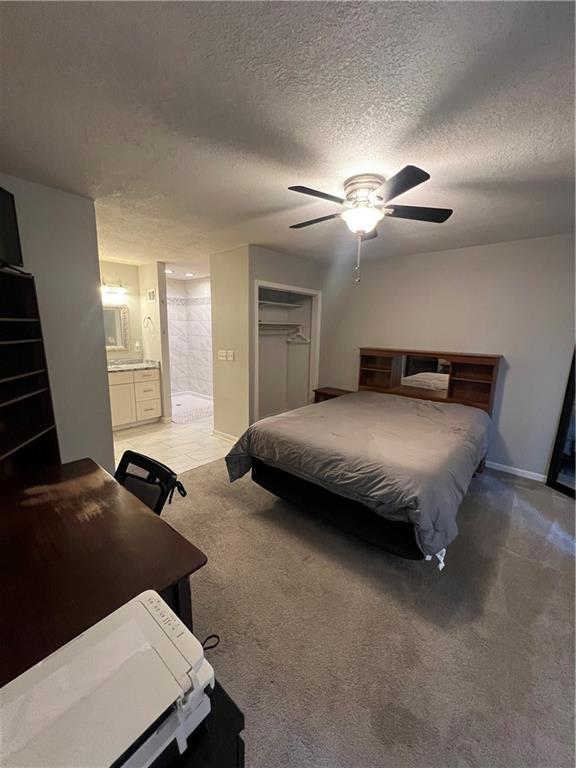 8237 N Chatham Ave, Kansas City, MO 64151 - bedroom featuring a textured ceiling, light carpet, ceiling fan, ensuite bathroom, and a closet