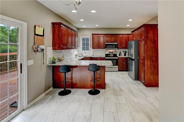 3403 E Devonshire Dr, Saint Joseph, MO 64506 - kitchen with appliances with stainless steel finishes, a sink, a peninsula, plenty of natural light, and recessed lighting
