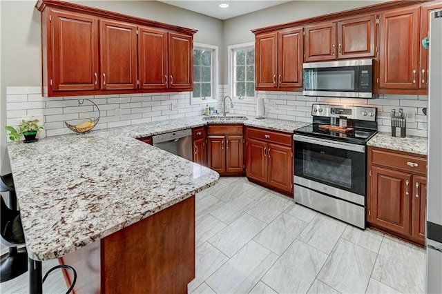 3403 E Devonshire Dr, Saint Joseph, MO 64506 - kitchen featuring appliances with stainless steel finishes, a peninsula, a sink, light stone counters, and recessed lighting