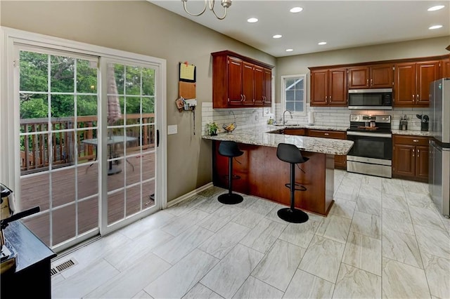 3403 E Devonshire Dr, Saint Joseph, MO 64506 - kitchen with stainless steel appliances, plenty of natural light, decorative backsplash, and recessed lighting