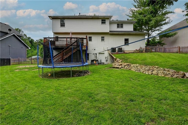 3403 E Devonshire Dr, Saint Joseph, MO 64506 - rear view of house with stairway, a wooden deck, and a trampoline