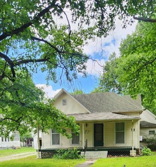 423 S Minnesota Ave, Columbus, KS 66725 - view of front of home with a porch and a front lawn