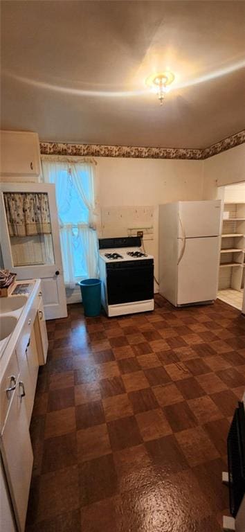 423 S Minnesota Ave, Columbus, KS 66725 - kitchen featuring white appliances, dark flooring, white cabinetry, and light countertops