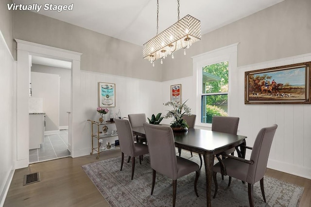 812 E Wabash St, Olathe, KS 66061 - dining space featuring a chandelier, wood finished floors, and a decorative wall