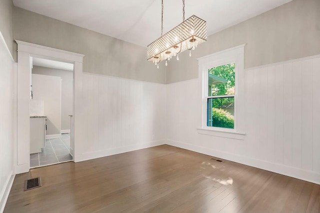 812 E Wabash St, Olathe, KS 66061 - empty room featuring hardwood / wood-style floors, a chandelier, and a wainscoted wall