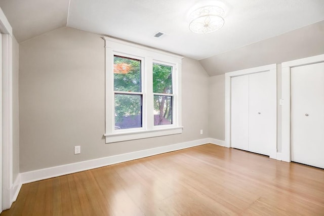 812 E Wabash St, Olathe, KS 66061 - unfurnished bedroom featuring lofted ceiling, wood finished floors, and multiple closets