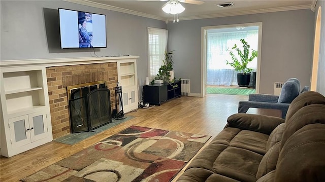 1146 S Willow St, Ottawa, KS 66067 - living area with wood finished floors, ceiling fan, built in features, crown molding, and a fireplace