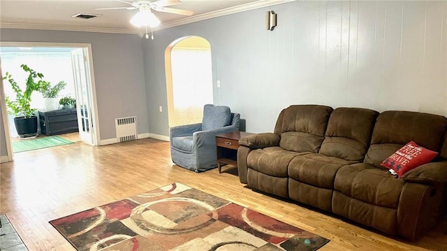 1146 S Willow St, Ottawa, KS 66067 - living area featuring radiator, arched walkways, wood finished floors, ceiling fan, and ornamental molding