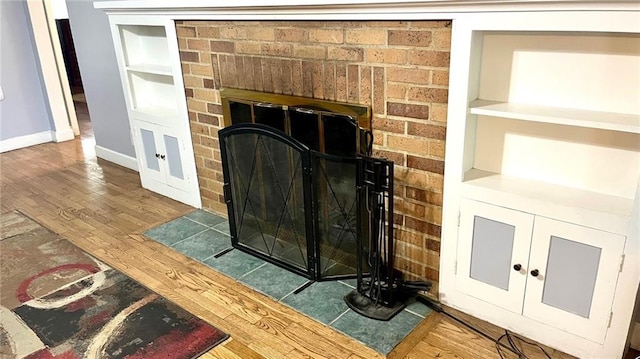 1146 S Willow St, Ottawa, KS 66067 - detailed view of a brick fireplace, baseboards, wood finished floors, and built in shelves