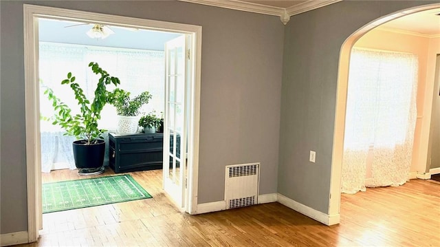 1146 S Willow St, Ottawa, KS 66067 - spare room featuring radiator heating unit, arched walkways, ornamental molding, wood finished floors, and baseboards