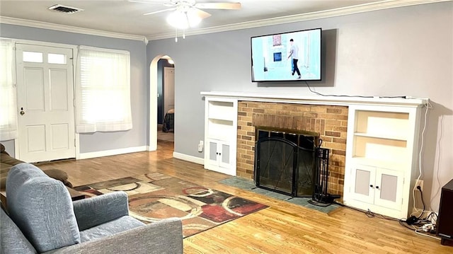 1146 S Willow St, Ottawa, KS 66067 - living room with arched walkways, wood finished floors, crown molding, ceiling fan, and a fireplace