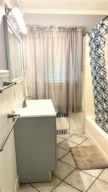 1146 S Willow St, Ottawa, KS 66067 - bathroom featuring vanity, crown molding, shower / tub combo with curtain, and tile patterned floors