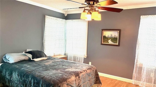 1146 S Willow St, Ottawa, KS 66067 - bedroom with multiple windows, wood finished floors, baseboards, a ceiling fan, and ornamental molding