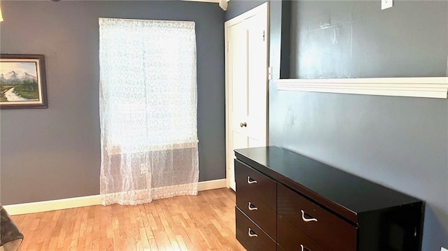 1146 S Willow St, Ottawa, KS 66067 - unfurnished bedroom with baseboards, multiple windows, and light wood-style flooring