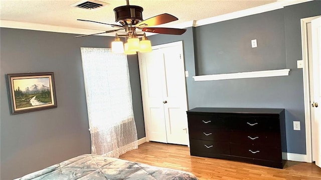 1146 S Willow St, Ottawa, KS 66067 - bedroom with light wood-type flooring, a textured ceiling, ceiling fan, baseboards, and crown molding