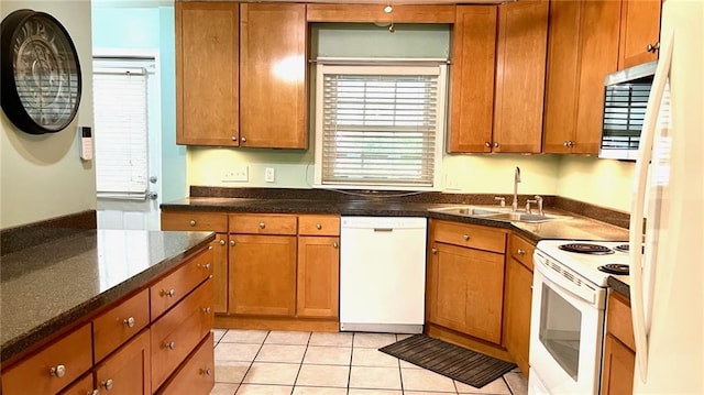 1146 S Willow St, Ottawa, KS 66067 - kitchen with white appliances, a sink, brown cabinets, light tile patterned flooring, and dark stone countertops