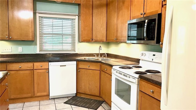 1146 S Willow St, Ottawa, KS 66067 - kitchen featuring white appliances, a sink, brown cabinetry, and light tile patterned flooring