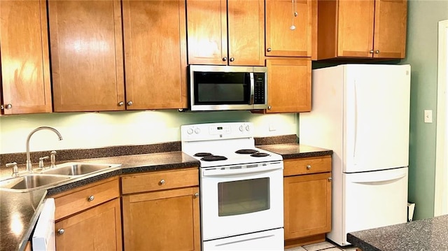 1146 S Willow St, Ottawa, KS 66067 - kitchen with white appliances, a sink, dark countertops, and brown cabinets