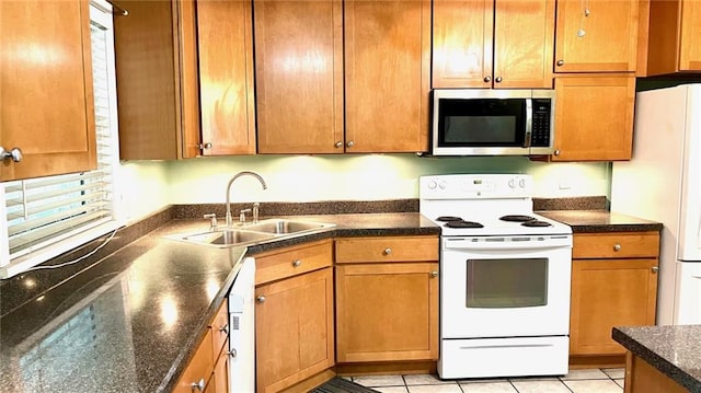1146 S Willow St, Ottawa, KS 66067 - kitchen with white appliances, a sink, brown cabinets, and light tile patterned flooring