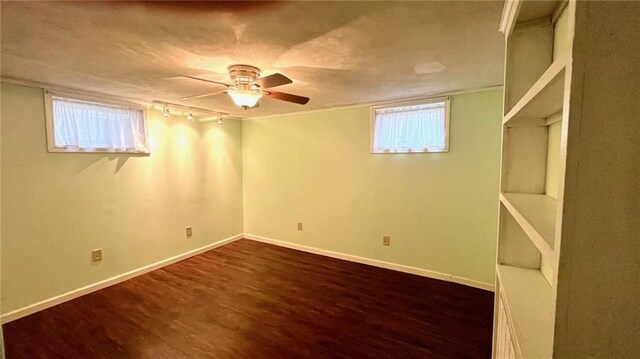 1146 S Willow St, Ottawa, KS 66067 - basement featuring dark wood-style flooring, a ceiling fan, rail lighting, and baseboards