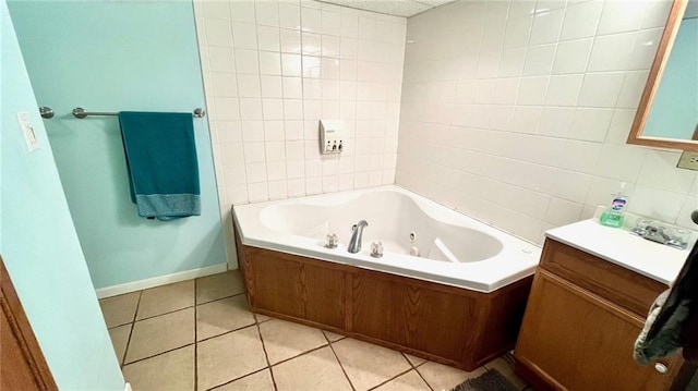 1146 S Willow St, Ottawa, KS 66067 - bathroom with a tub with jets, vanity, tile patterned flooring, tile walls, and baseboards