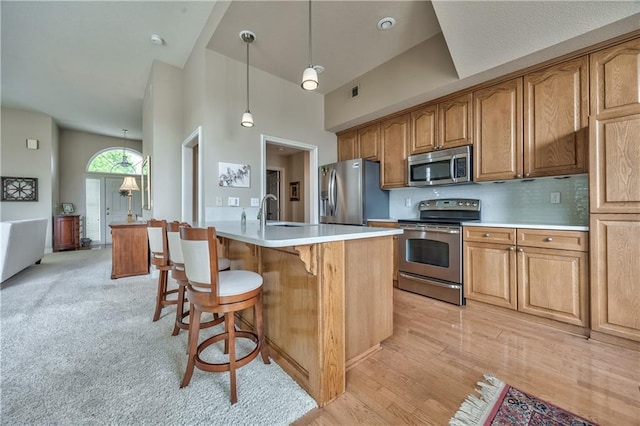 12207 England St, Overland Park, KS 66213 - kitchen with stainless steel appliances, a high ceiling, light countertops, a sink, and a kitchen breakfast bar