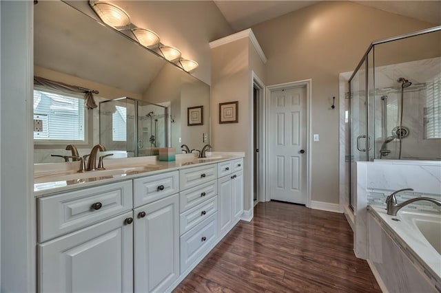 12207 England St, Overland Park, KS 66213 - full bathroom featuring lofted ceiling, double vanity, a garden tub, a shower stall, and wood finished floors