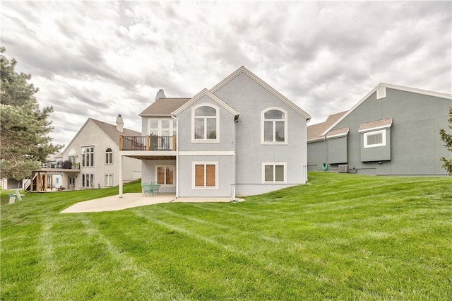12207 England St, Overland Park, KS 66213 - rear view of house with a patio area, a lawn, stucco siding, and a balcony
