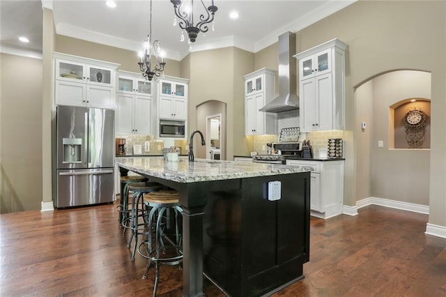 16570 S Ingrid St, Gardner, KS 66030 - kitchen with appliances with stainless steel finishes, wall chimney exhaust hood, arched walkways, a chandelier, and a sink
