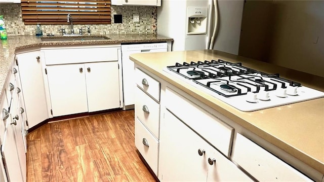 1441 S Maple St, Ottawa, KS 66067 - kitchen featuring white appliances, backsplash, white cabinets, light wood finished floors, and light countertops