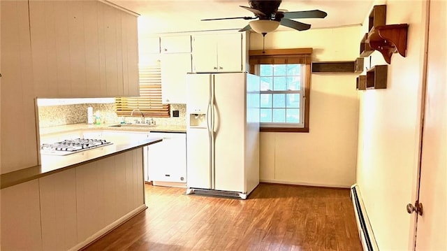 1441 S Maple St, Ottawa, KS 66067 - kitchen featuring white appliances, a baseboard heating unit, light wood-type flooring, ceiling fan, and light countertops