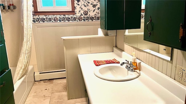 1441 S Maple St, Ottawa, KS 66067 - bathroom featuring baseboard heating, wainscoting, vanity, wallpapered walls, and shower / bath combo