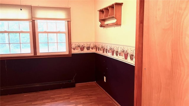 1441 S Maple St, Ottawa, KS 66067 - unfurnished room with baseboard heating, wood finished floors, and a wainscoted wall