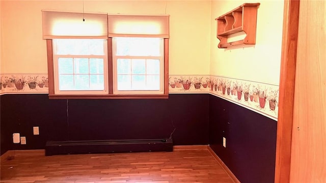1441 S Maple St, Ottawa, KS 66067 - spare room with a baseboard heating unit, wood finished floors, and wainscoting